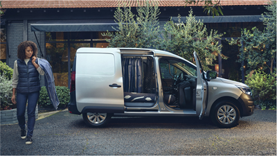 A woman walking outside the Renault Express Van with doors opened